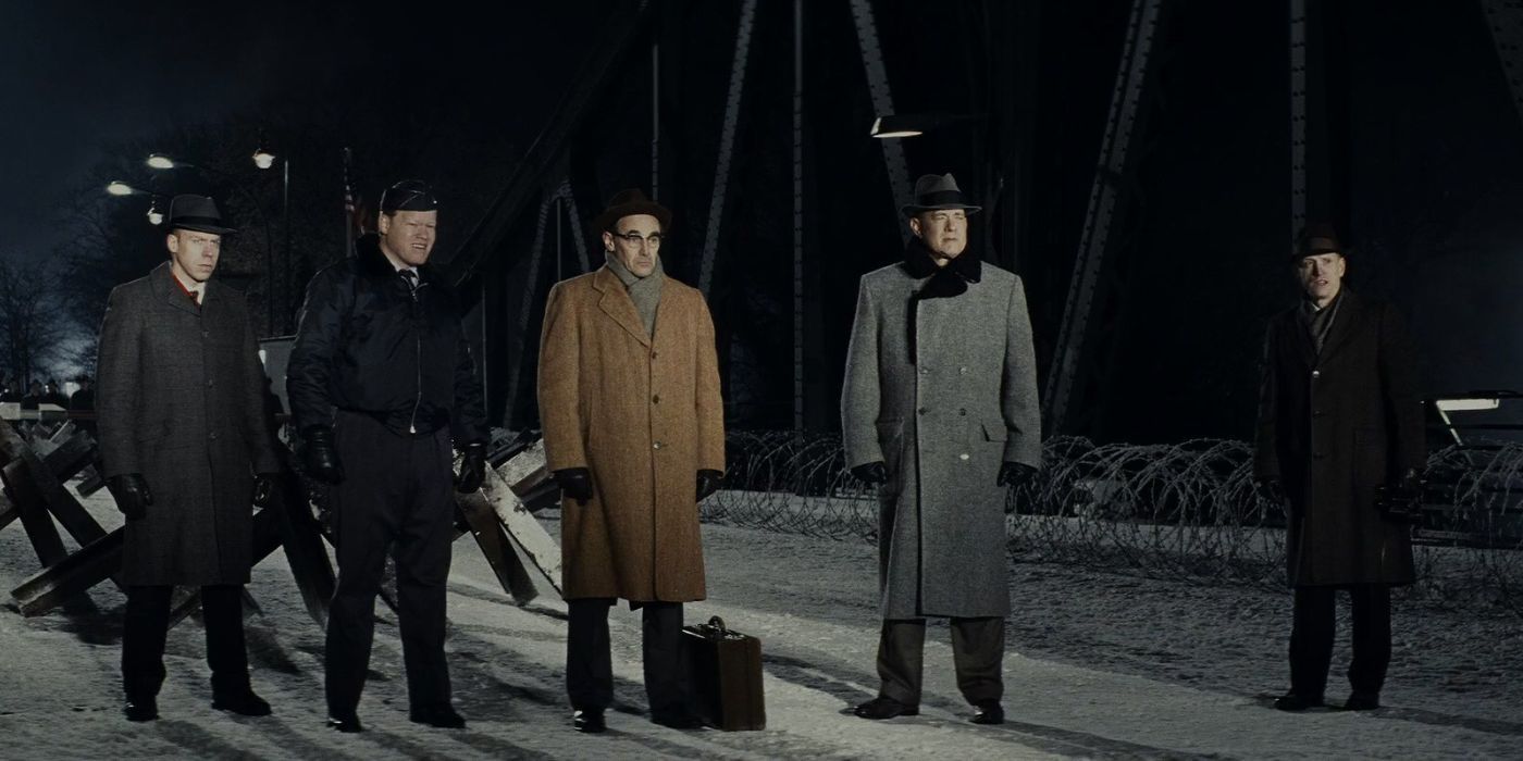 Five men standing in line on a bridge at night in Bridge of Spies