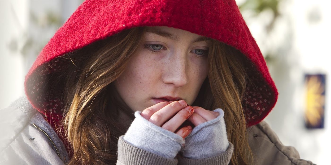 Saoirse Ronan as Eleanor with blood on her fingers and a hood on in Byzantium