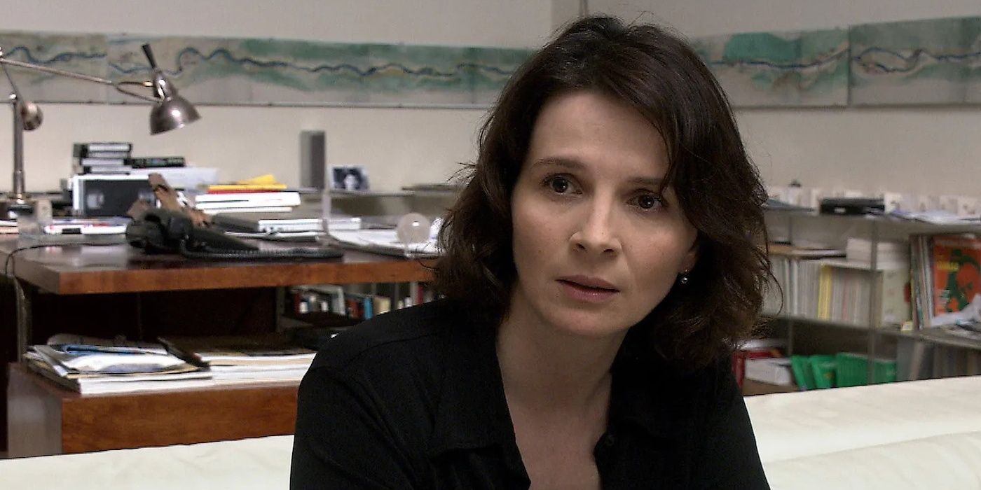 Juliette Binoche está sentada en casa, preocupada.