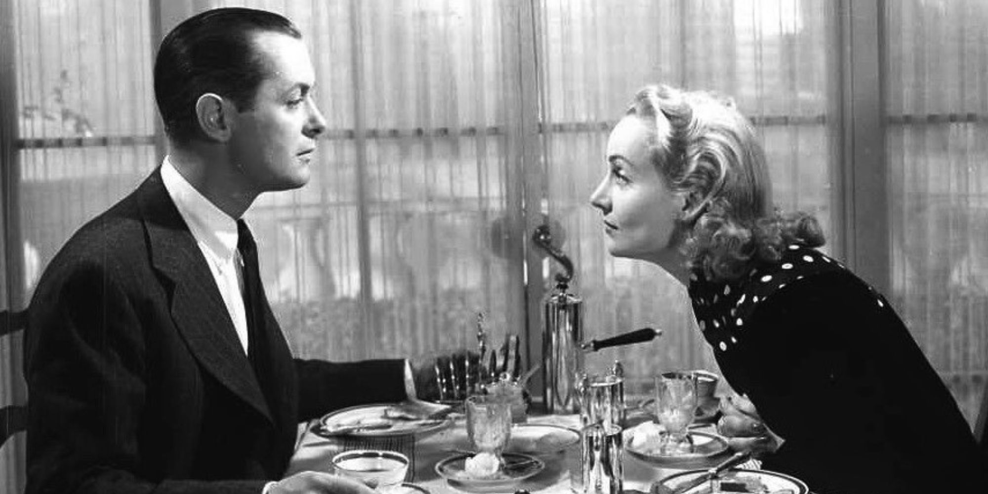 Carole Lombard leaning across a table looking at Robert Montgomery in Mr. &amp; Mrs. Smith (1941)-1