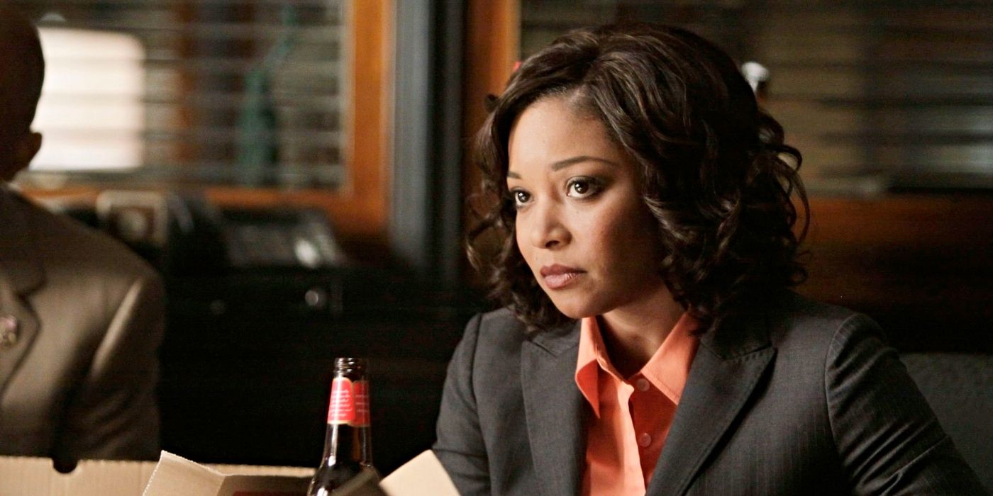 Tamala Jones as Dr. Lanie Parish, sitting at a table wearing a blazer with a beer in front of her on Castle