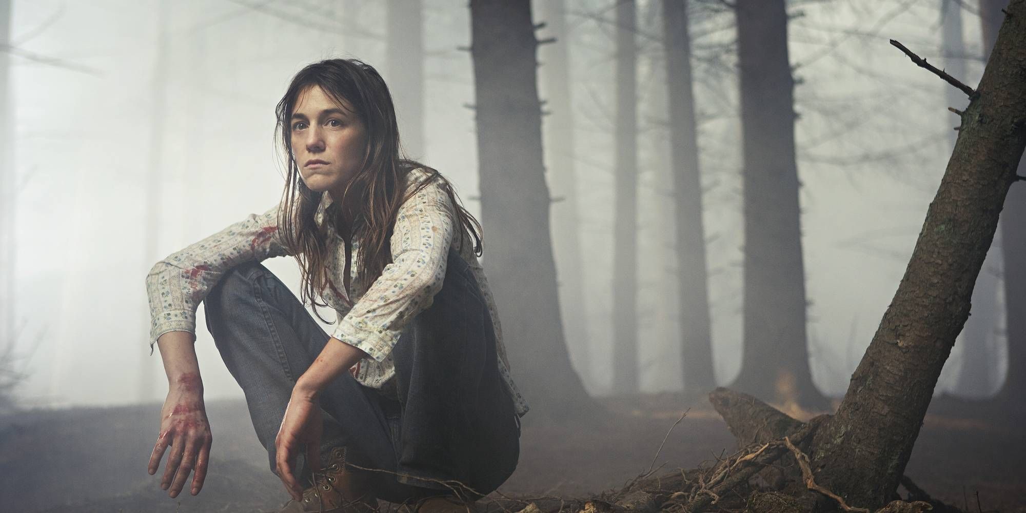 Charlotte Gainsbourg squatting down in a forest in Antichrist.