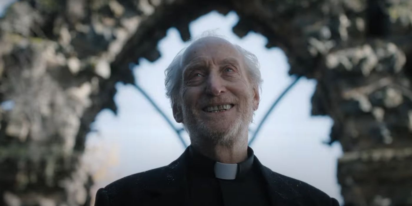 Charles Dance giving a disturbed grin as Father Harris in The First Omen.