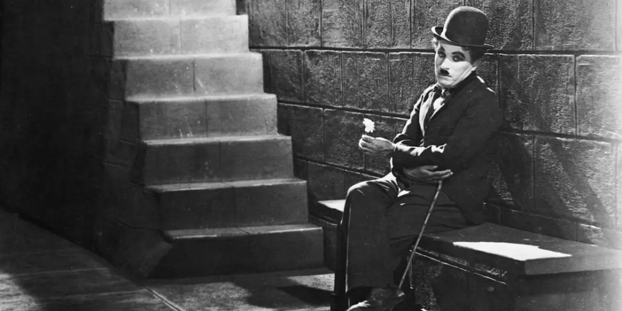 Chaplin's Tramp sits on a staircase in 'City Lights'