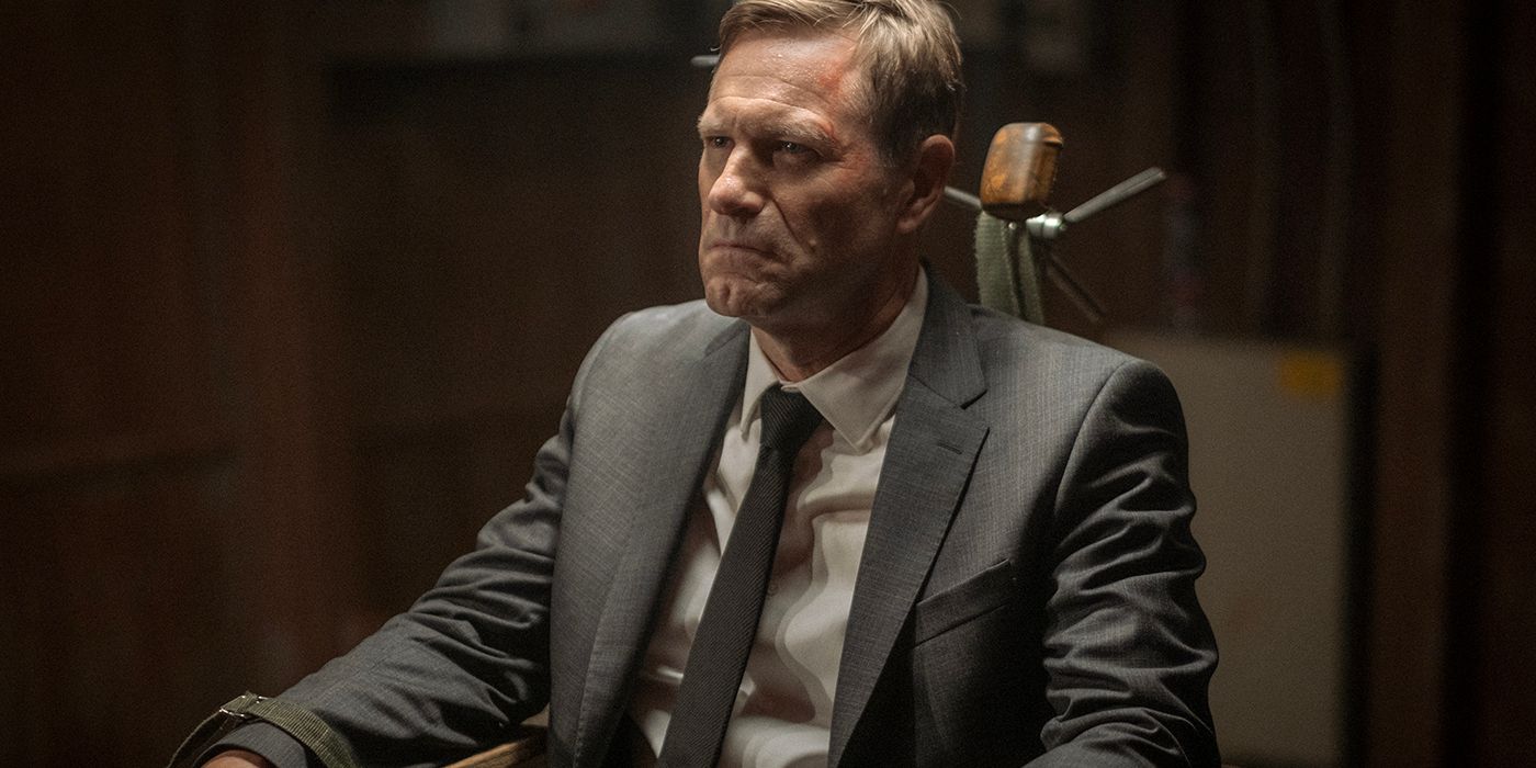 Aaron Eckhart sits in a chair in Chief of Station 
