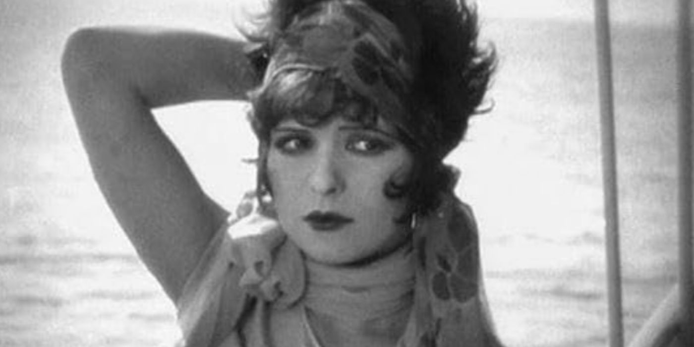 Clara Bow with her arm over her head looking to the side with sea behind her in 1927&rsquo;s &lsquo;It&rsquo;