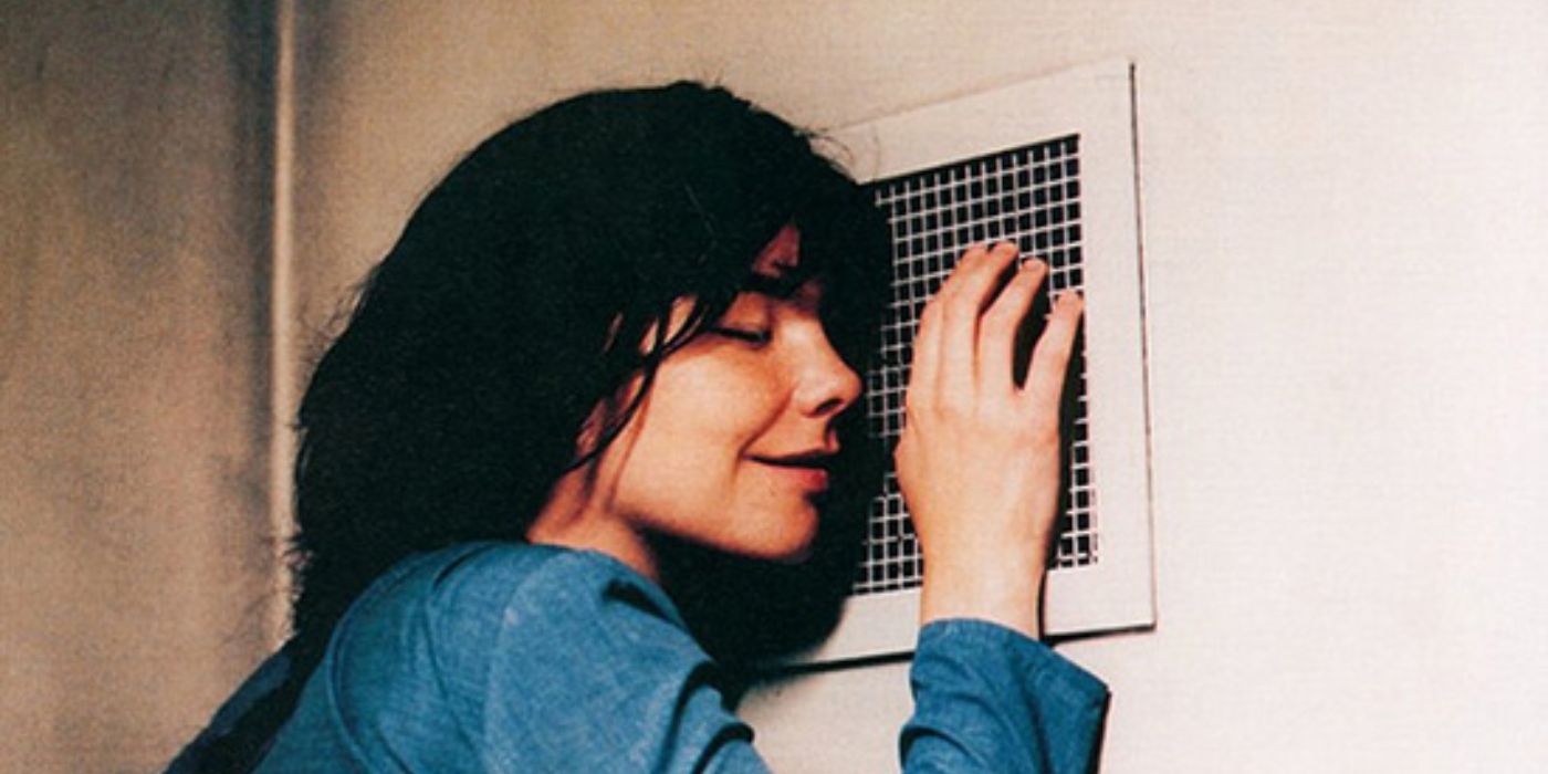 Selma (Bjork) smiles while leaning against a ventilation cover on the wall