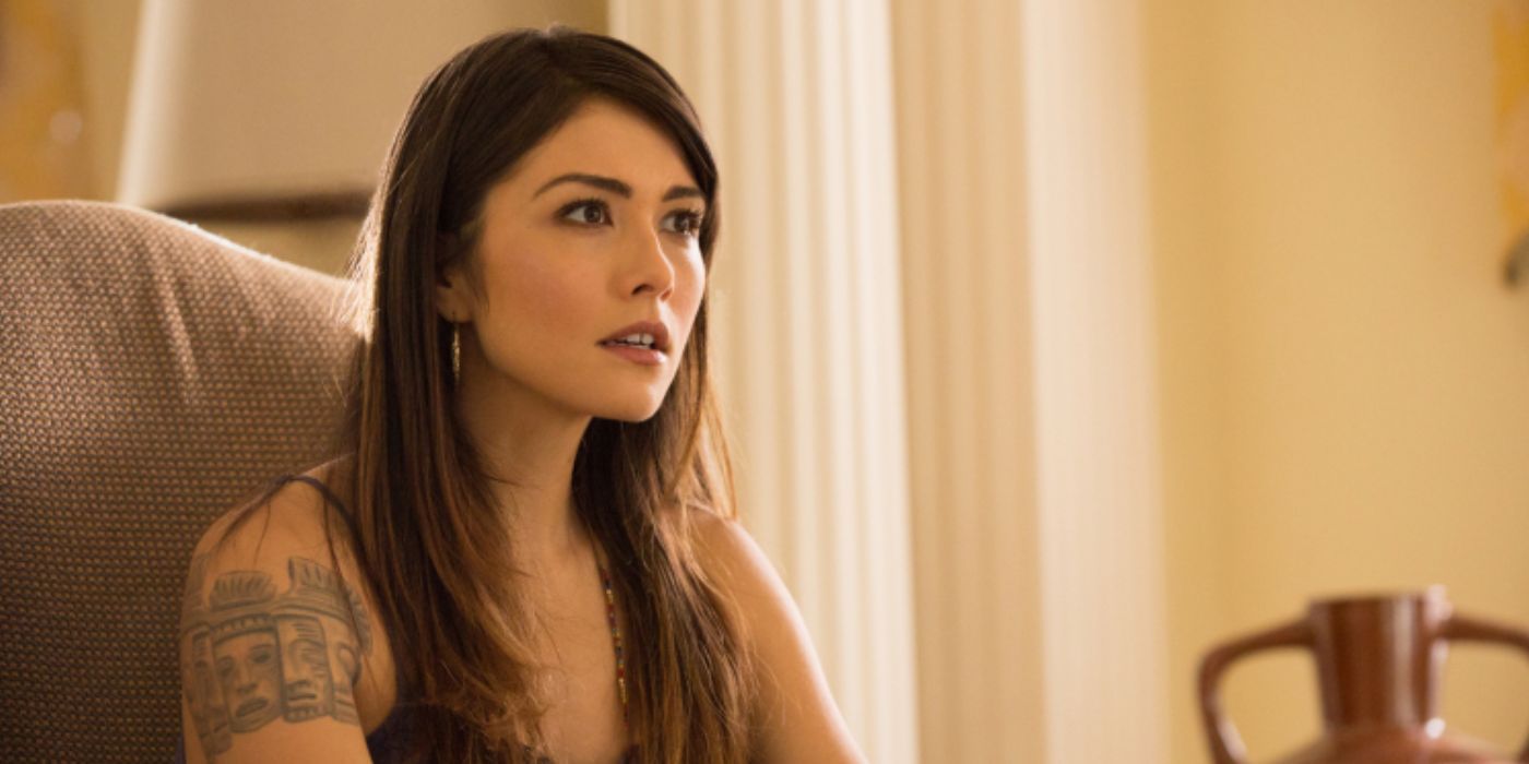 Daniella Pineda is sitting in an armchair and talking in a scene from 'The Originals`.