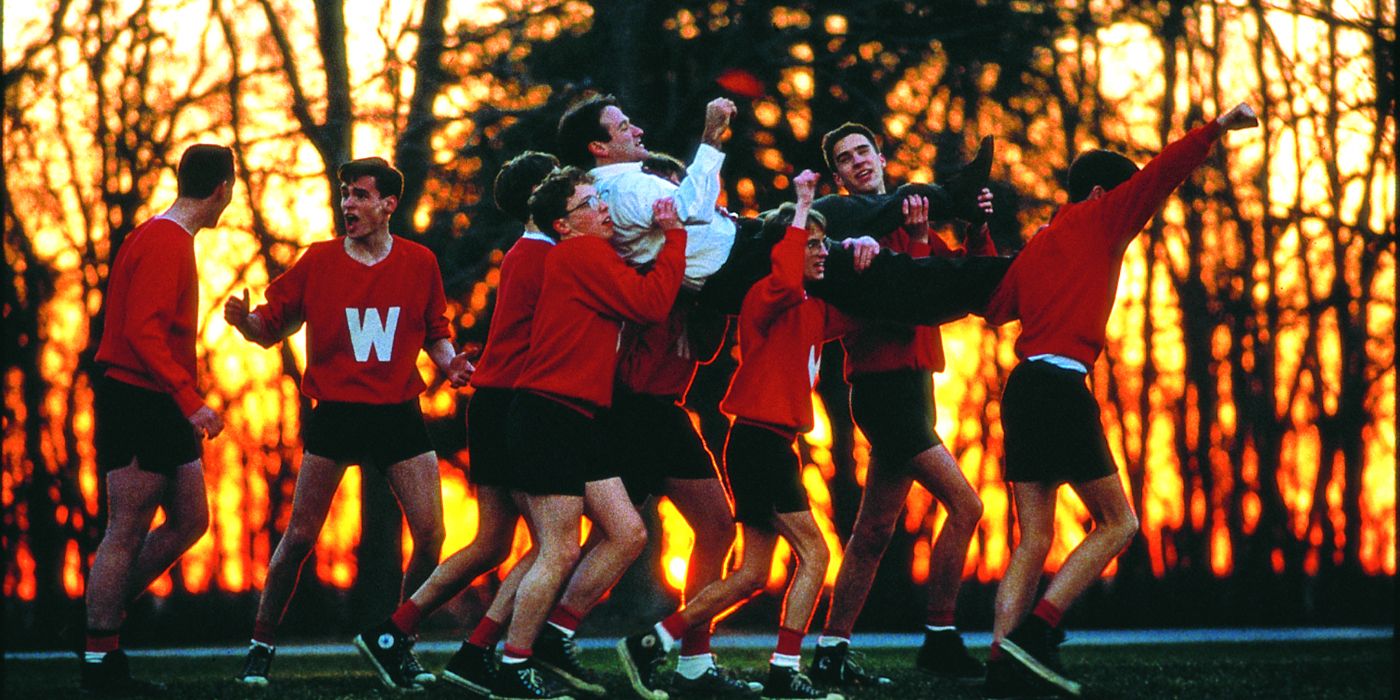 A group of students wearing red and black sports uniforms and joyfully carrying John Keating (Robin Williams) across a field in Dead Poets Society