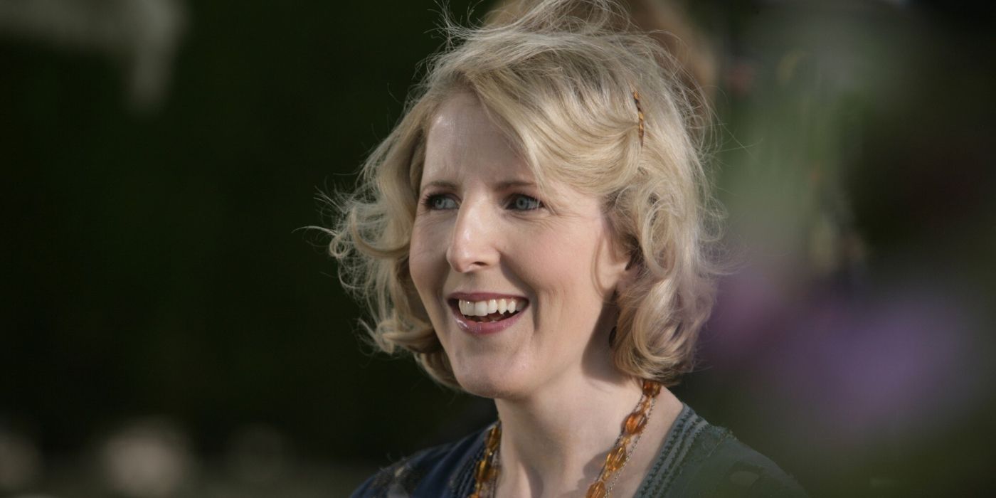 A close up of Agatha Christie (Fenella Woolgar) smiling and looking toward the left with the wind slightly blowing her hair in Doctor Who