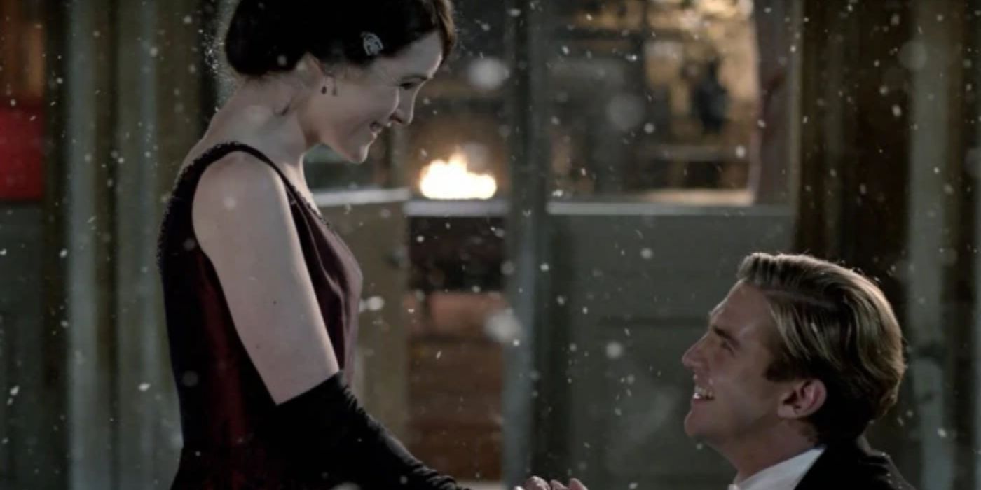 Dan Stevens as Matthew kneels and proposes to Michelle Dockery as Mary in the snow in Downton Abbey.