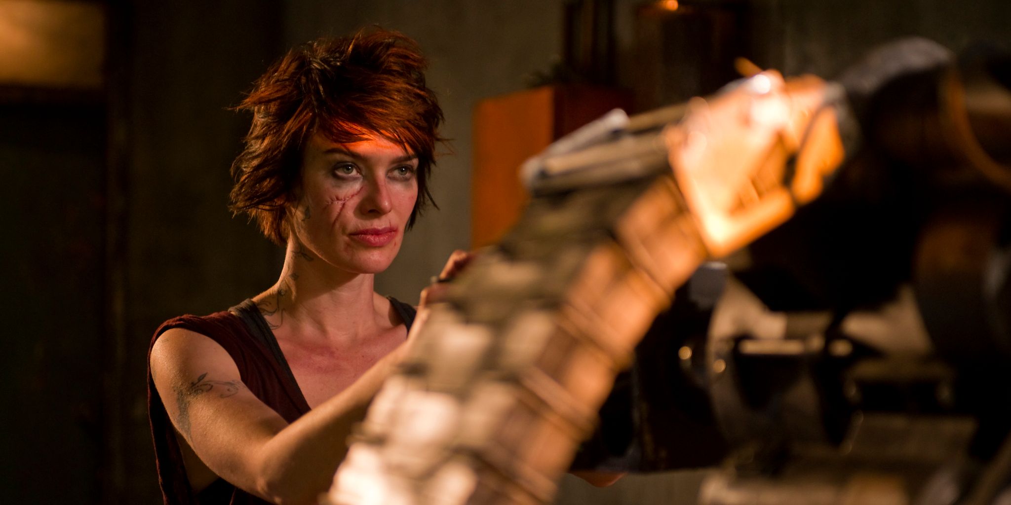 Lena Headey as Ma-Ma handling a massive minigun in Dredd