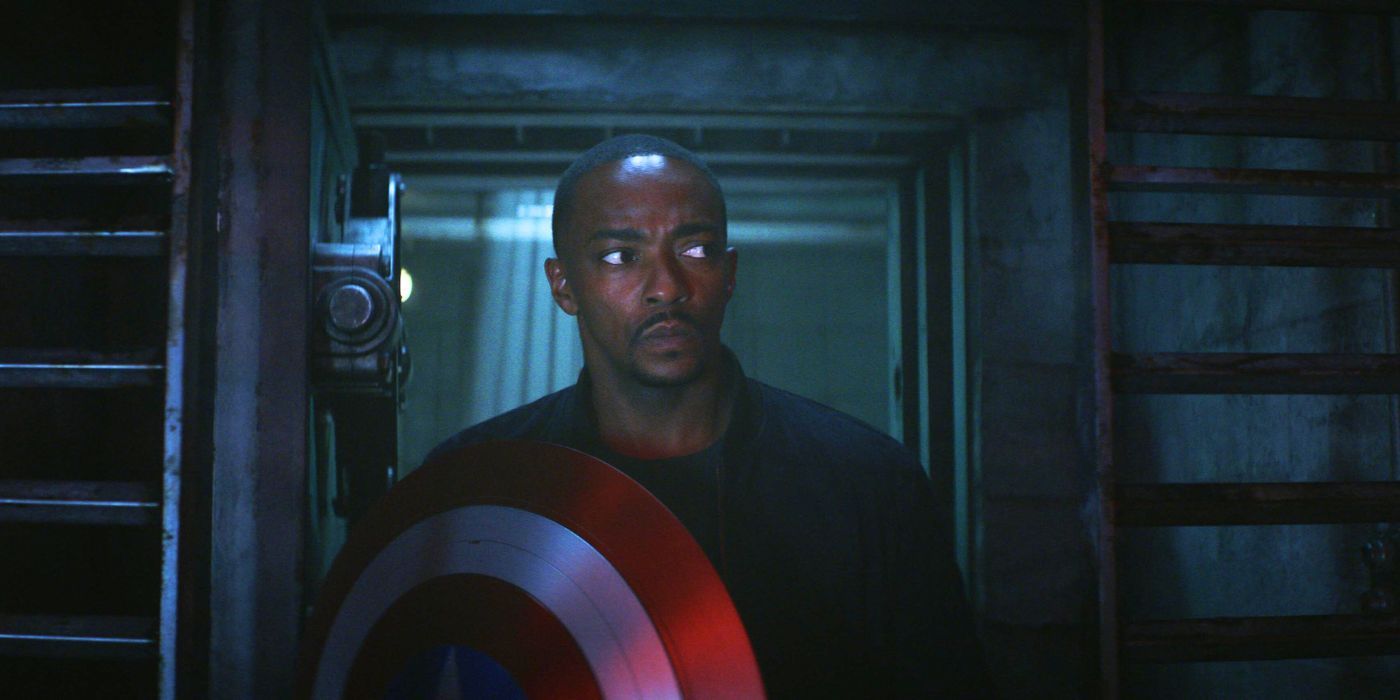 Anthony Mackie as Sam Wilson holding up his shield while walking into a dark room in Captain America: Brave New World.