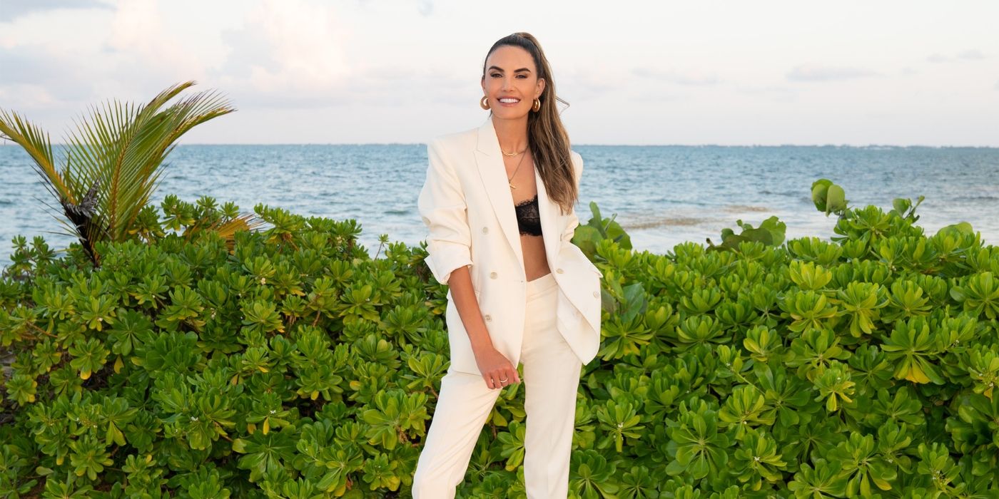Elizabeth Chambers standing in a white suit in front of the ocean