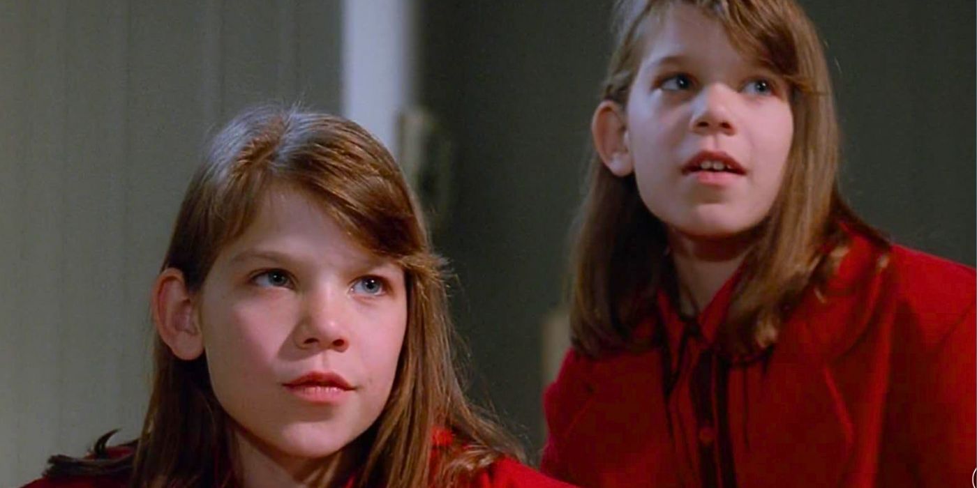 Erika and Sabrina Krievins as Eve clones stand together wearing matching creepy red jackets in episode Eve from The X-Files