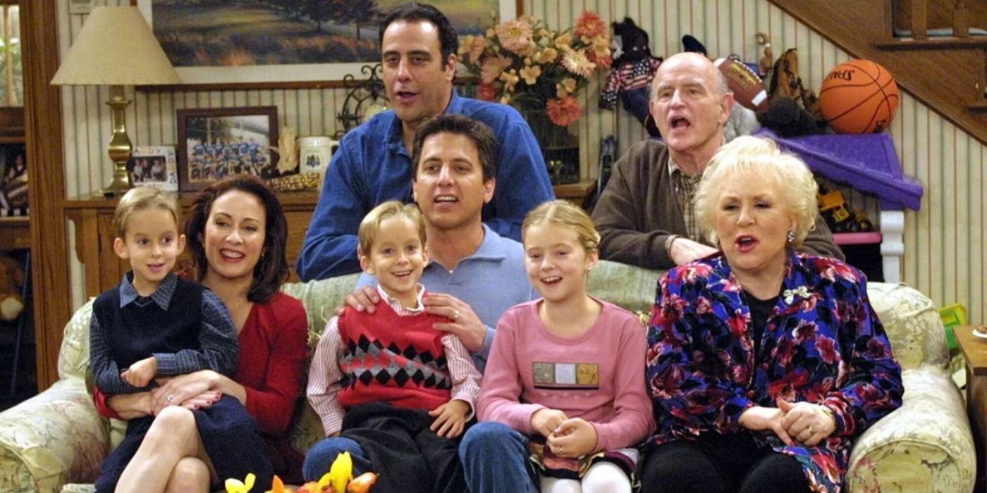 Top row, l to r: Raymond & Frank, standing behind a couch. Bottom Row, l to r: Geoffrey, Debra, Michael, Robert, Ally, & Marie, sitting on the couch