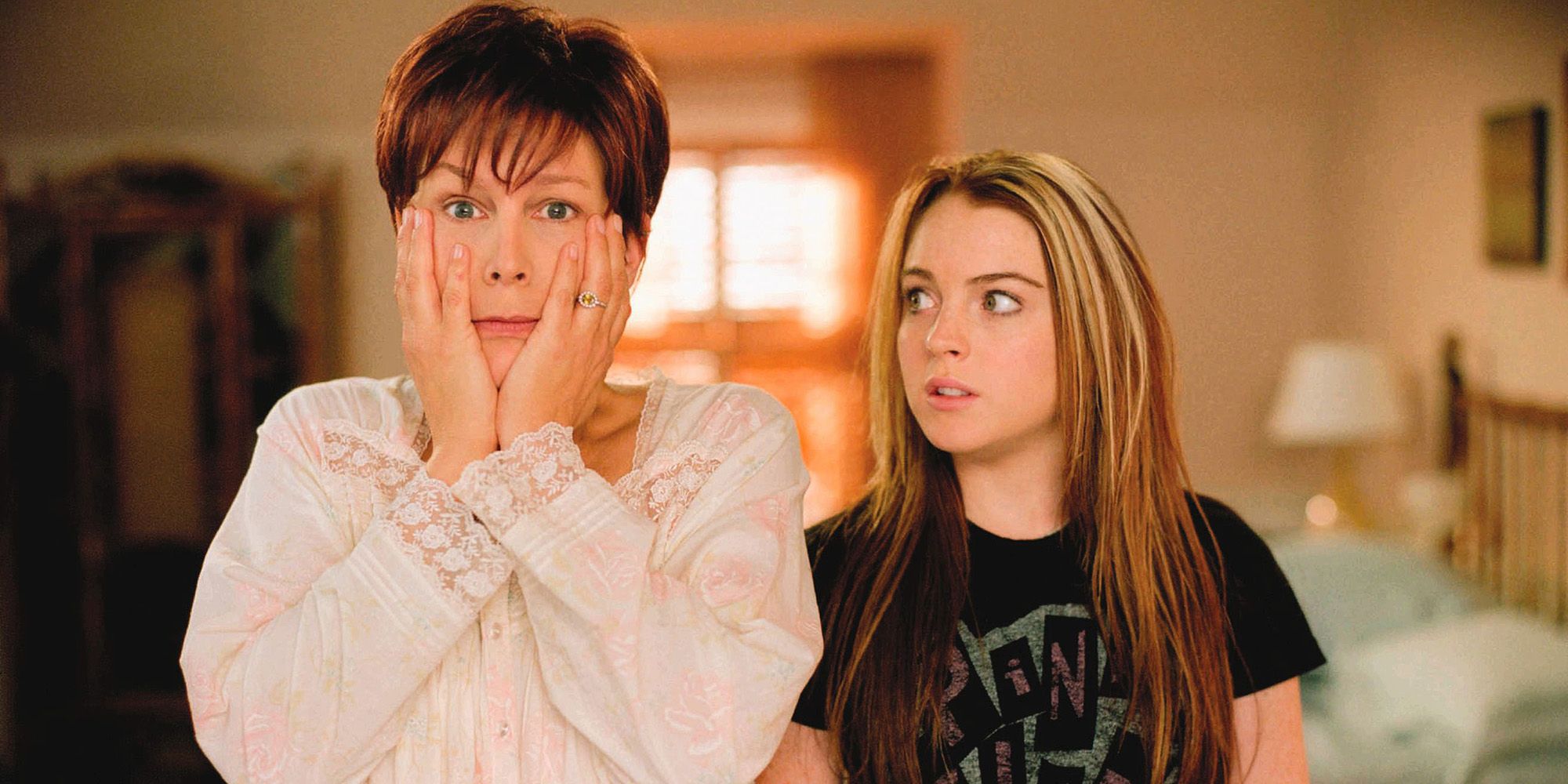 Jamie Lee Curtis holding her face while Lindsay Lohan looks at her in Freaky Friday 