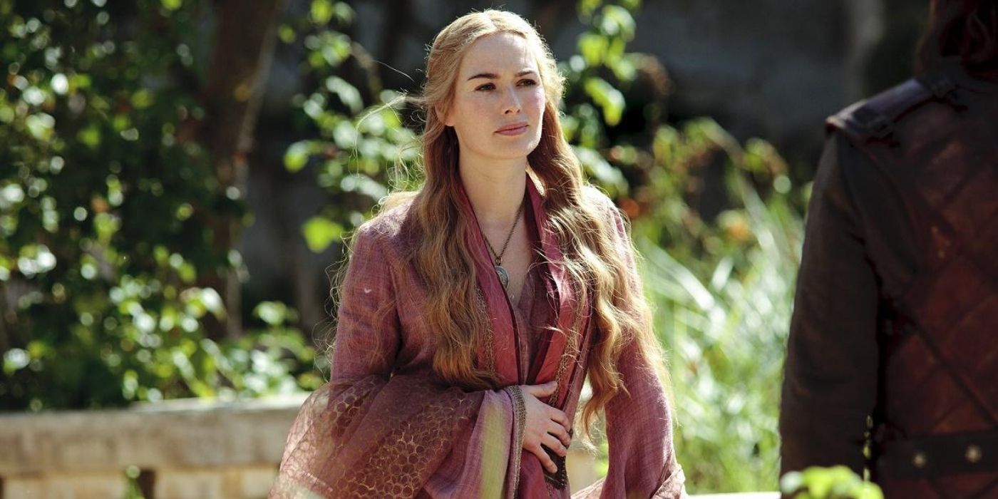 Cersei Lannister (Lena Headey) stands in a courtyard wearing a red dress and gown as she confronts Eddard Stark (Sean Bean) in 'Game of Thrones' Season 1, Episode 7 "You Win or You Die" (2011).