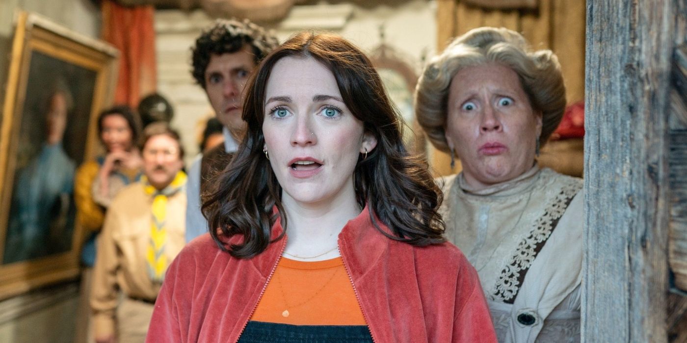 Charlotte Ritchie as Alison Cooper, looking shocked while the ghosts stand behind her in Ghosts