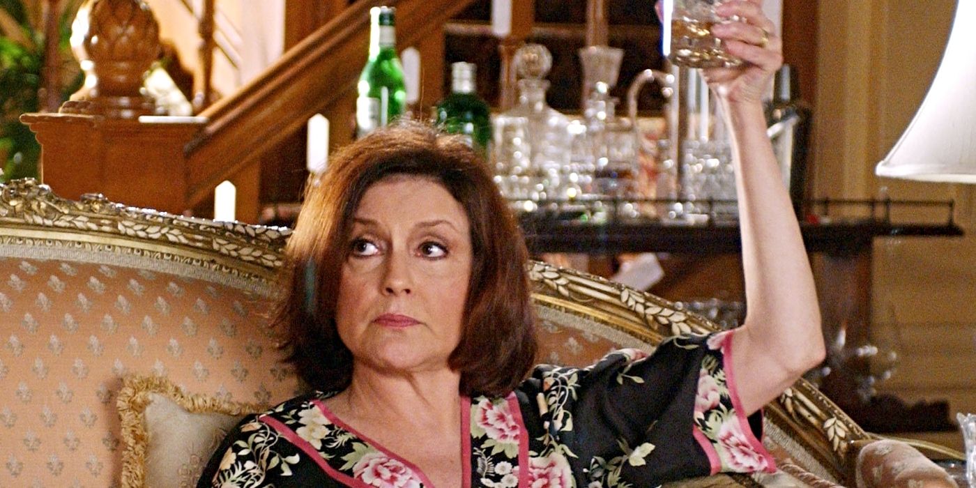 Kelly Bishop as Emily Gilmore, wearing a silk robe and holding up a glass of whiskey on Gilmore Girls