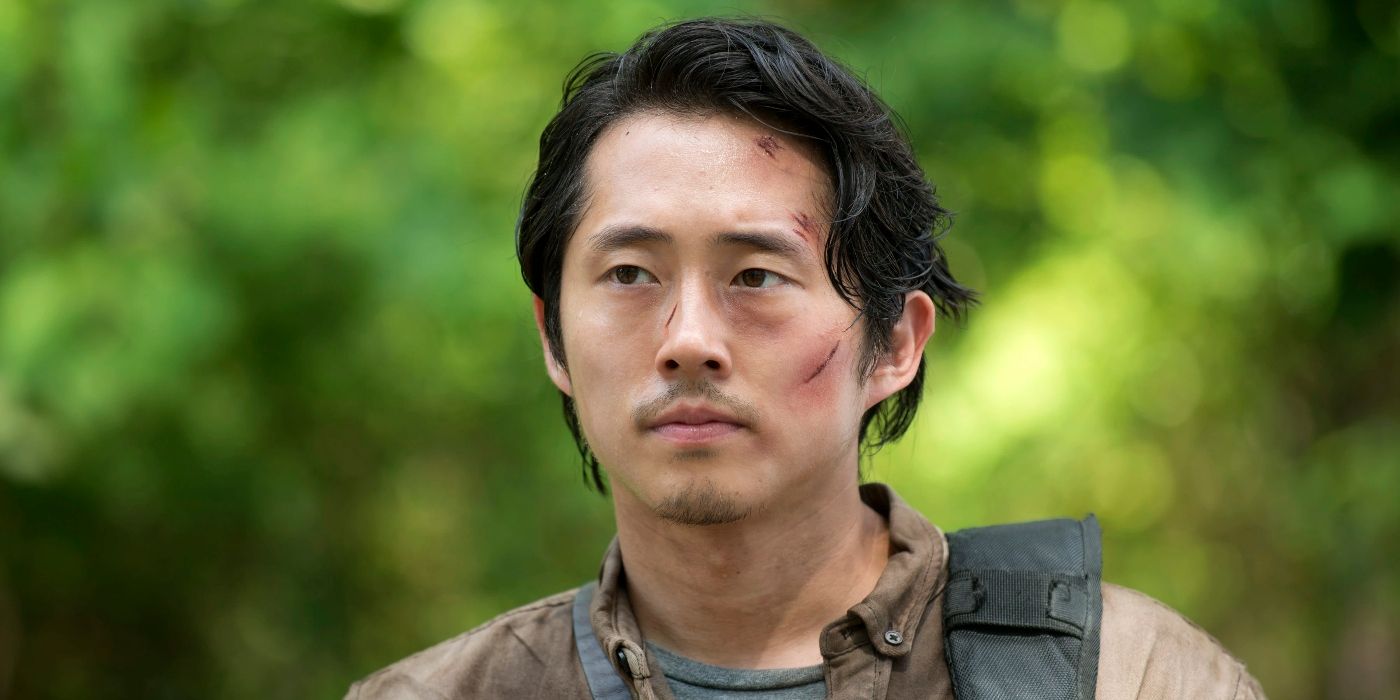 Steven Yeun as Glenn Rhee, standing outside with cuts on his face in The Walking Dead