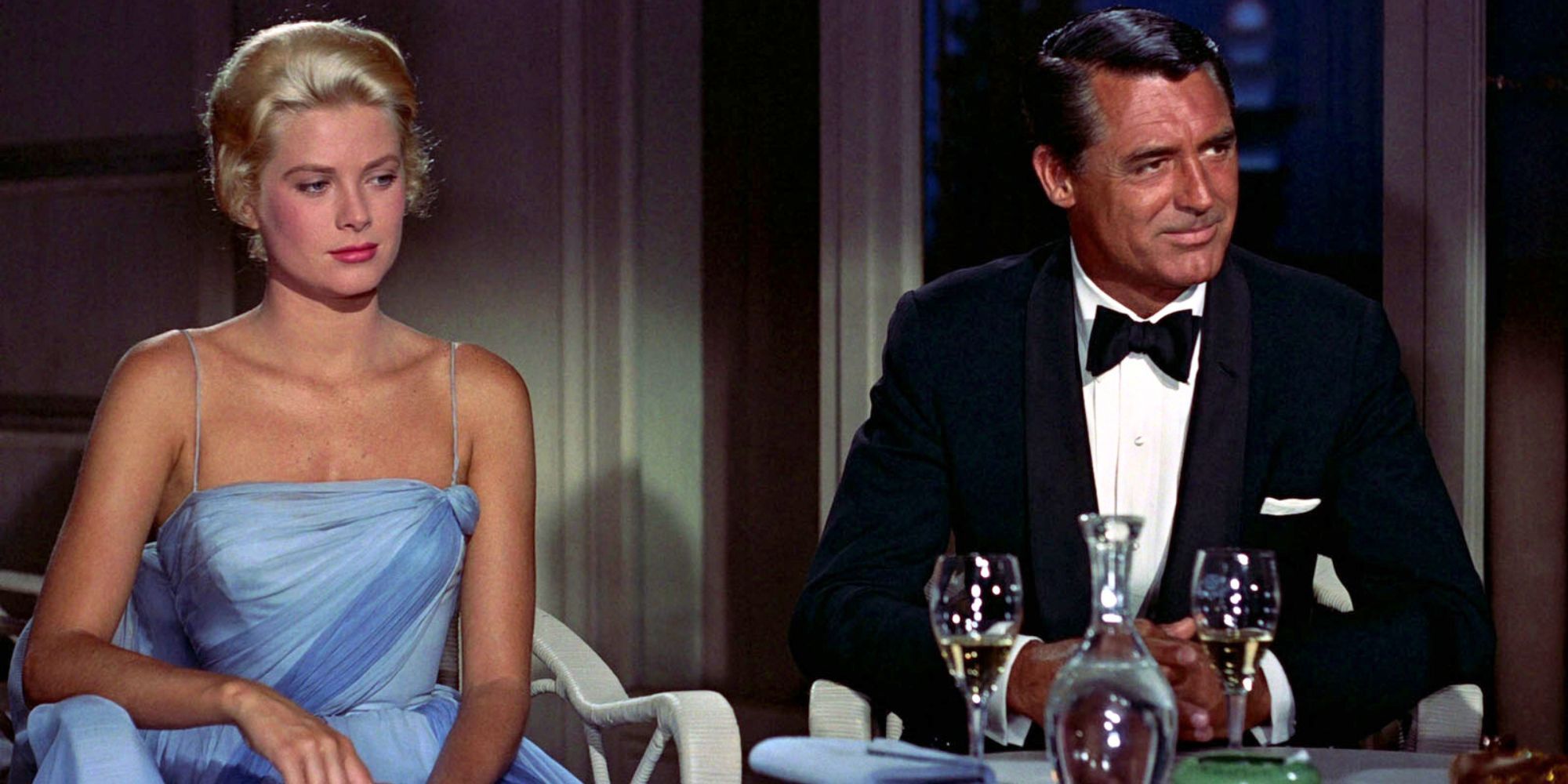 Grace Kelly sitting next to Cary Grant at a table with empty glasses in To Catch a Thief (1955)