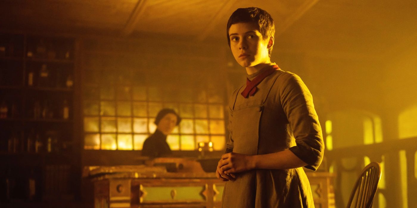 Gretel (Sophia Lillis) stands in a witch's alluring home, basked in warm golden light in 'Gretel & Hansel' (2020)