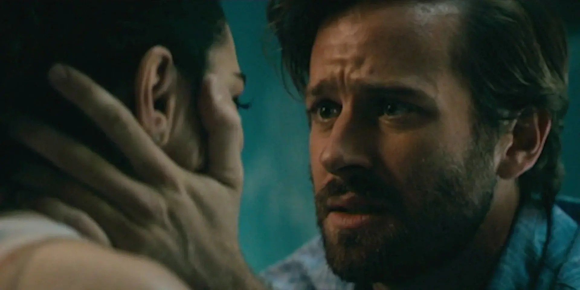 A still from Hotel Mumbai featuring Armie Hammer as David consoling and comforting a woman by holding her face