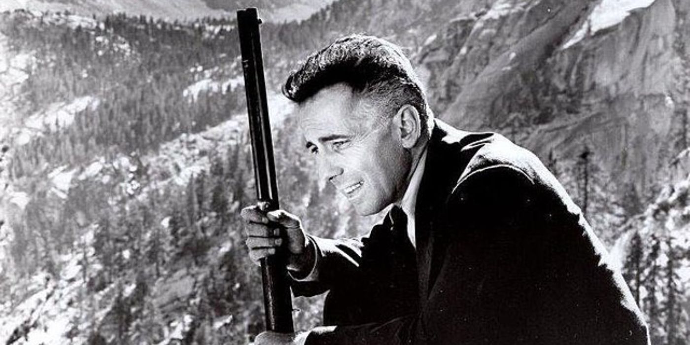 Humphrey Bogart as Roy Earle in 'High Sierra' with a rifle on a mountain.