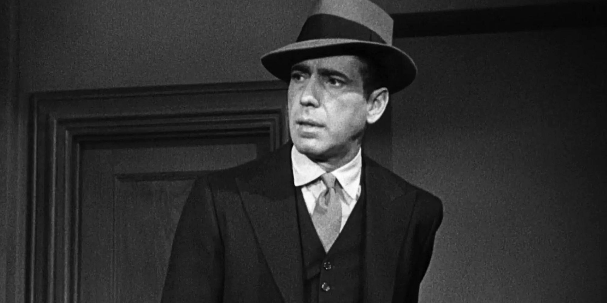 Humphrey Bogart looks serious in a suit as Sam Spade in The Maltese Falcon (1941)