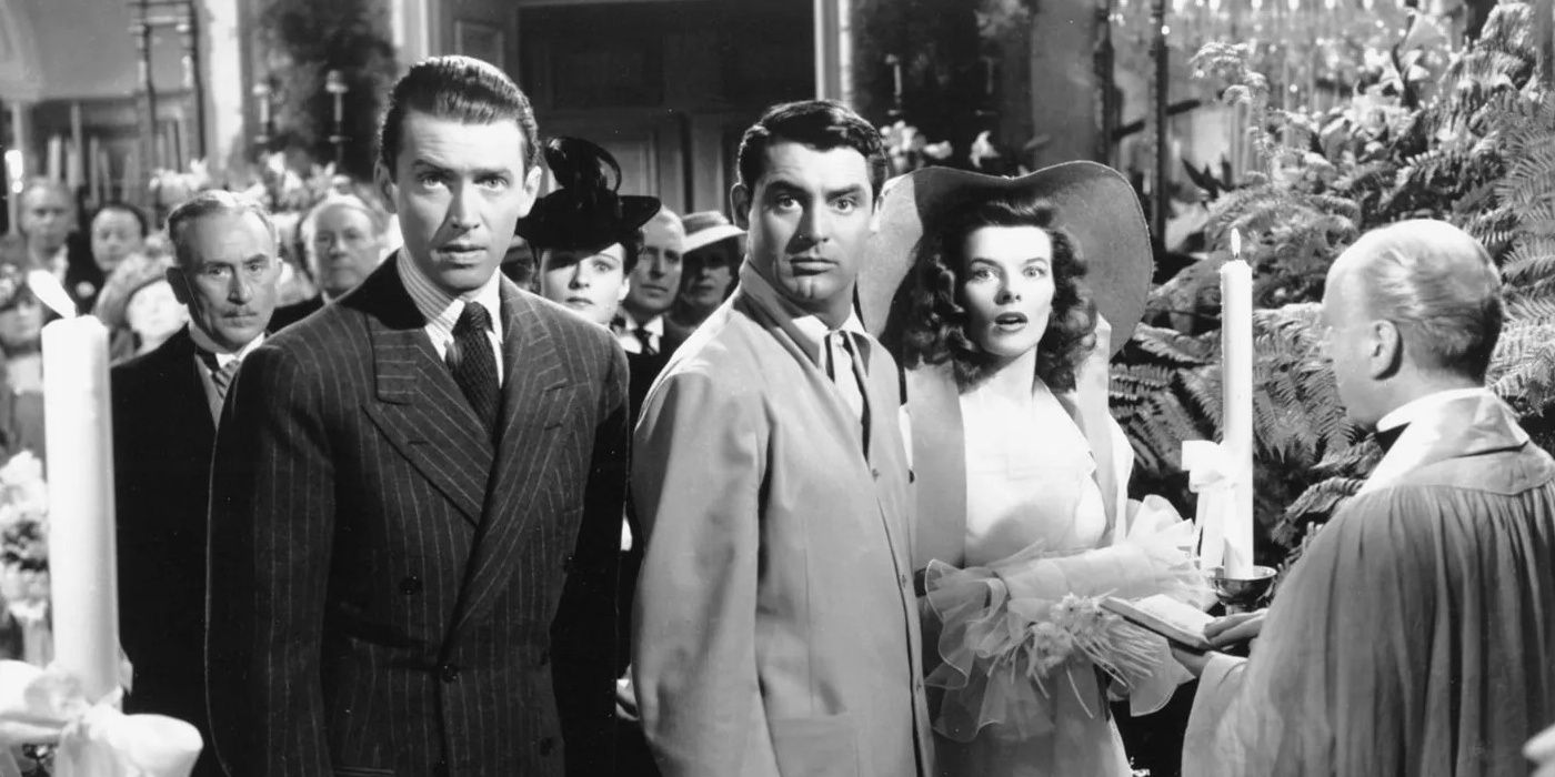 Katharine Hepburn, Cary Grant, and James Stewart looking int he same direction with shocked expressions in 'The Philadelphia Story'