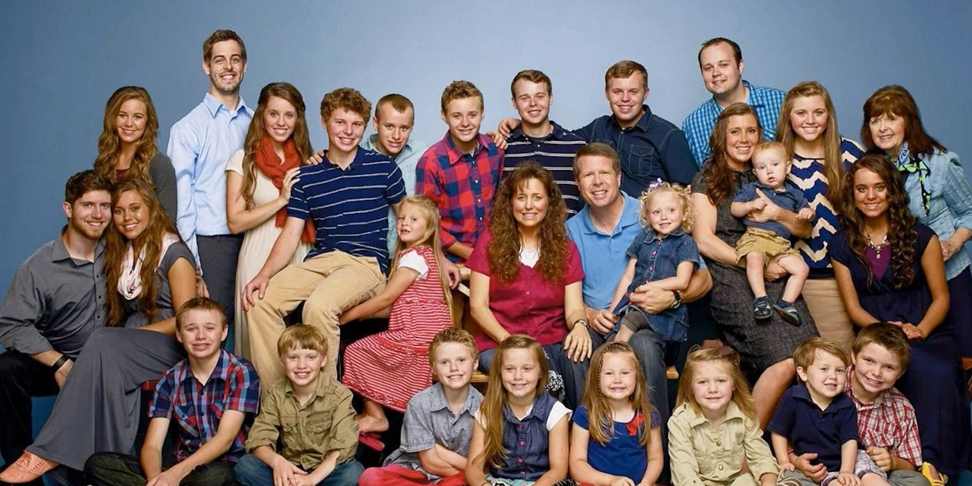 A promotional photo showing Jim Bob and Michelle Duggar with their 19 children, and the spouses and children from their adult children's marriages