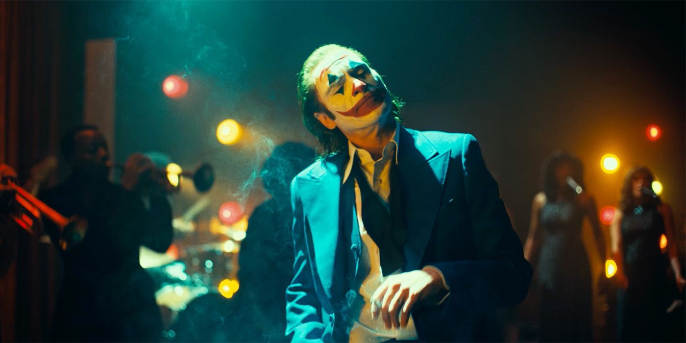 Joaquin Phoenix como Arthur Fleck con maquillaje de payaso y los ojos cerrados en Joker: Folie á Deux