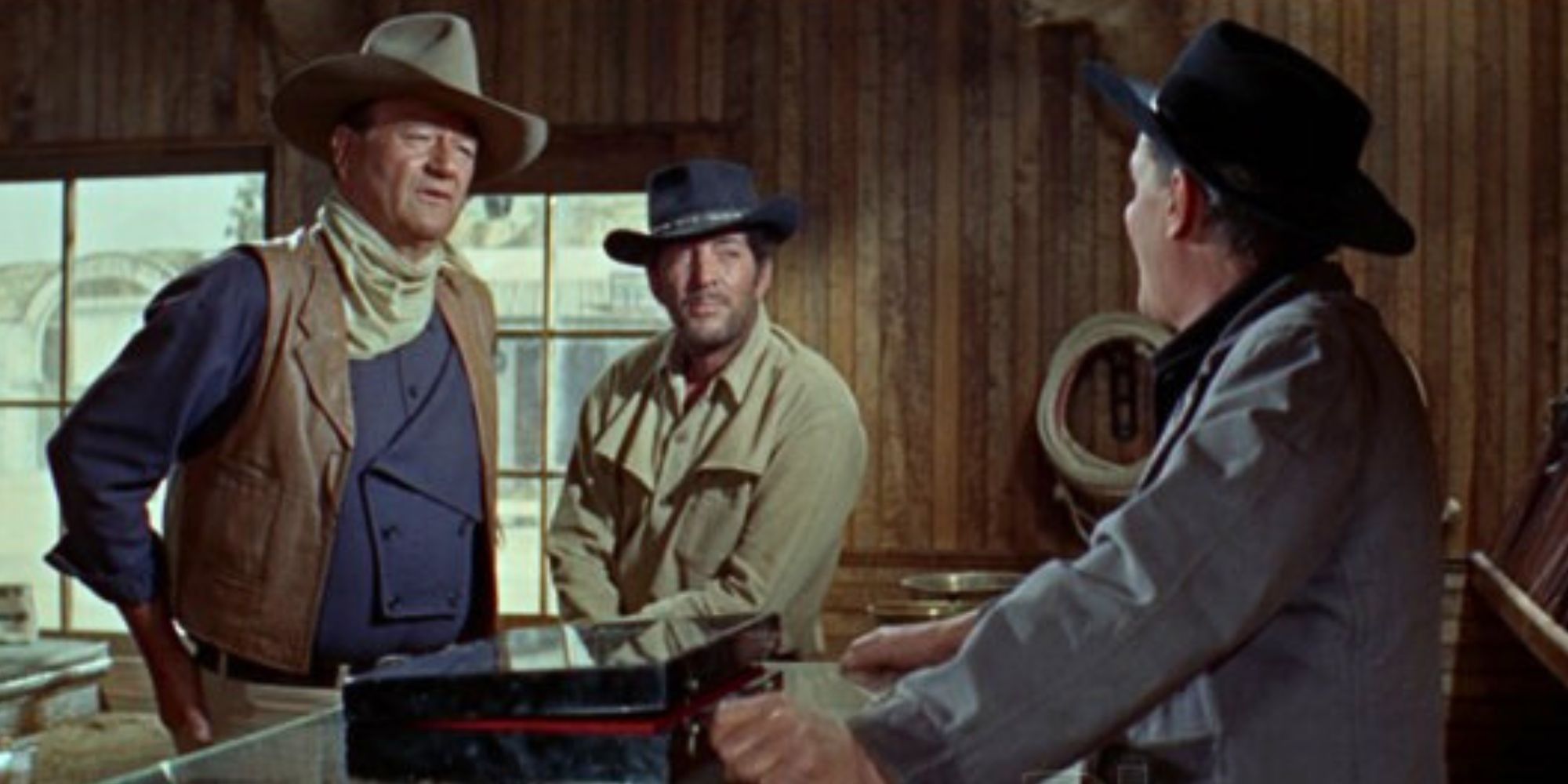 John Wayne standing with Dean Martin at counter while talking to a man on the other side in The Sons of Katie Elder (1965)