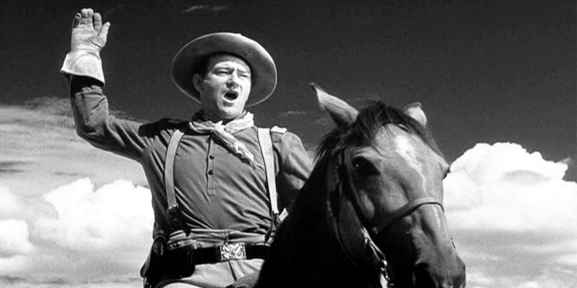 John Wayne as Captain Kirby York on horseback signaling to a person offscreen in Fort Apache (1948)