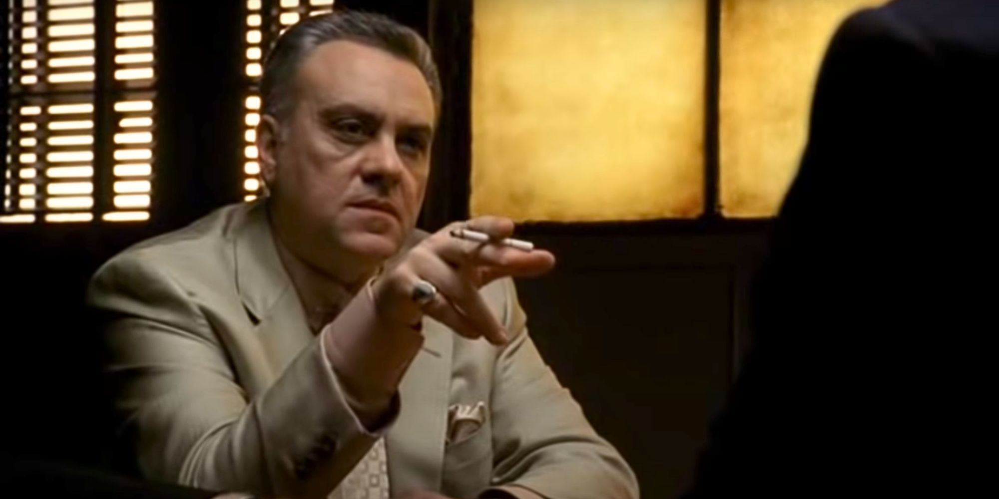 Vincent Curatola as Johnny Sack sitting at a table point his finger at someone in The Sopranos-2
