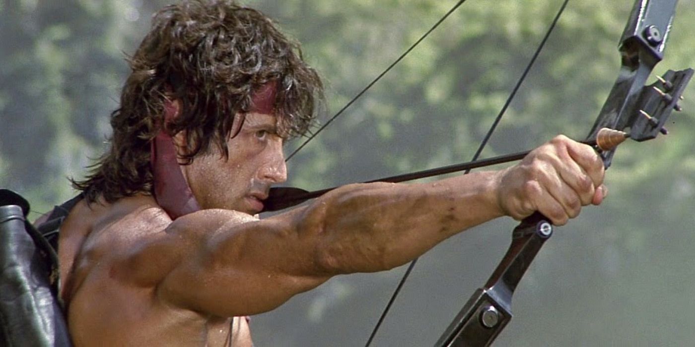 Rambo (Sylvester Stallone) stands with his bow drawn