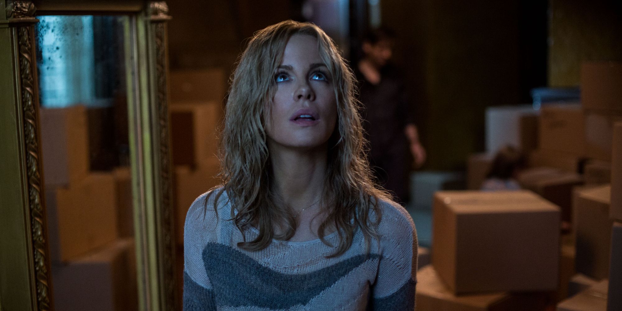 Kate Beckinsale looking up while unpacking moving boxes in The Disappointments Room (2016)