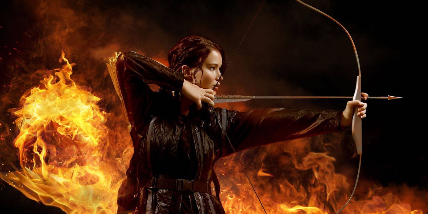 Promotional image for 'The Hunger Games' featuring Katniss (Jennifer Lawrence) standing with her bow drawn against a fiery backdrop