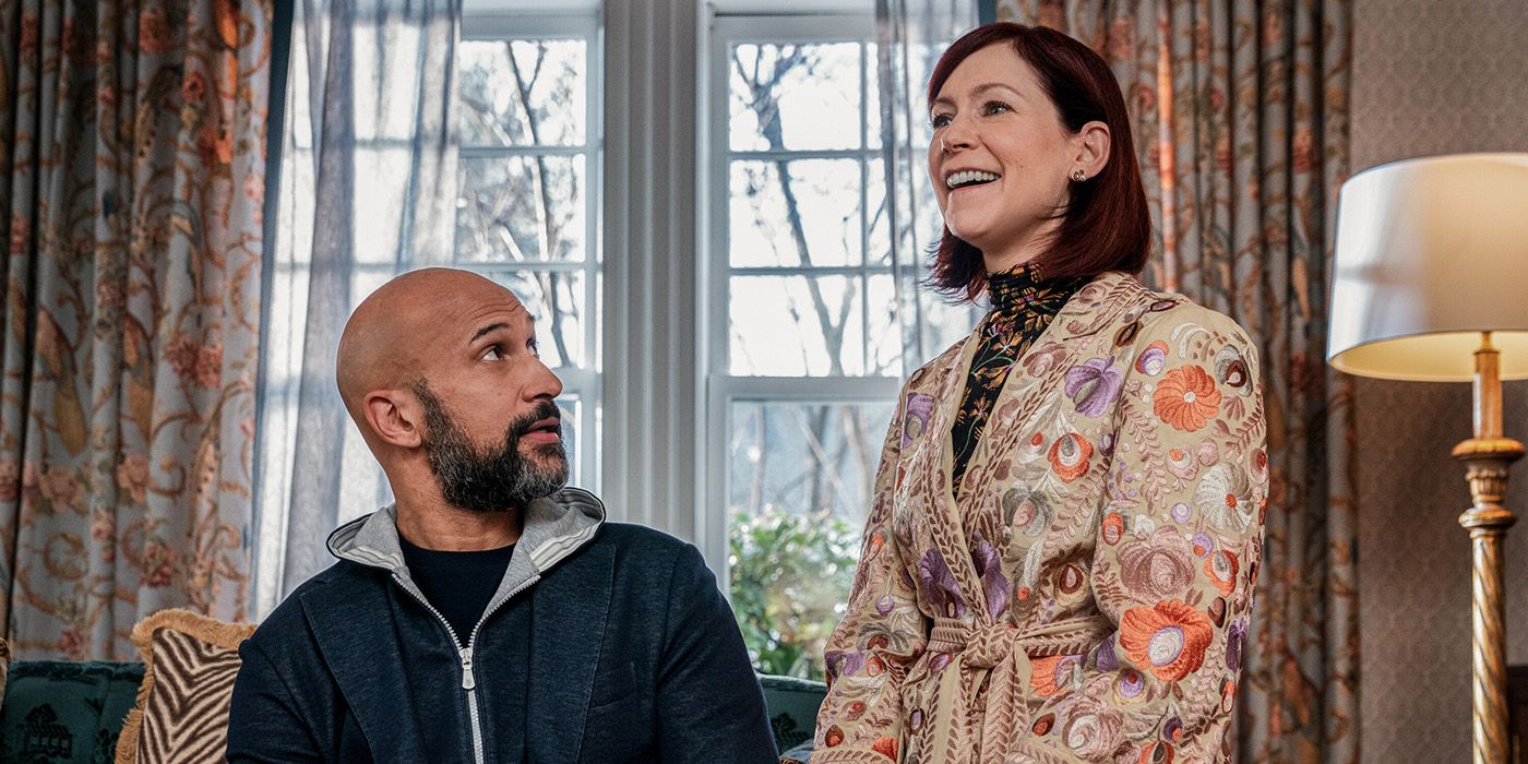 Carrie Preston and Keegan Michael Key sitting together in a living room in Elsbeth