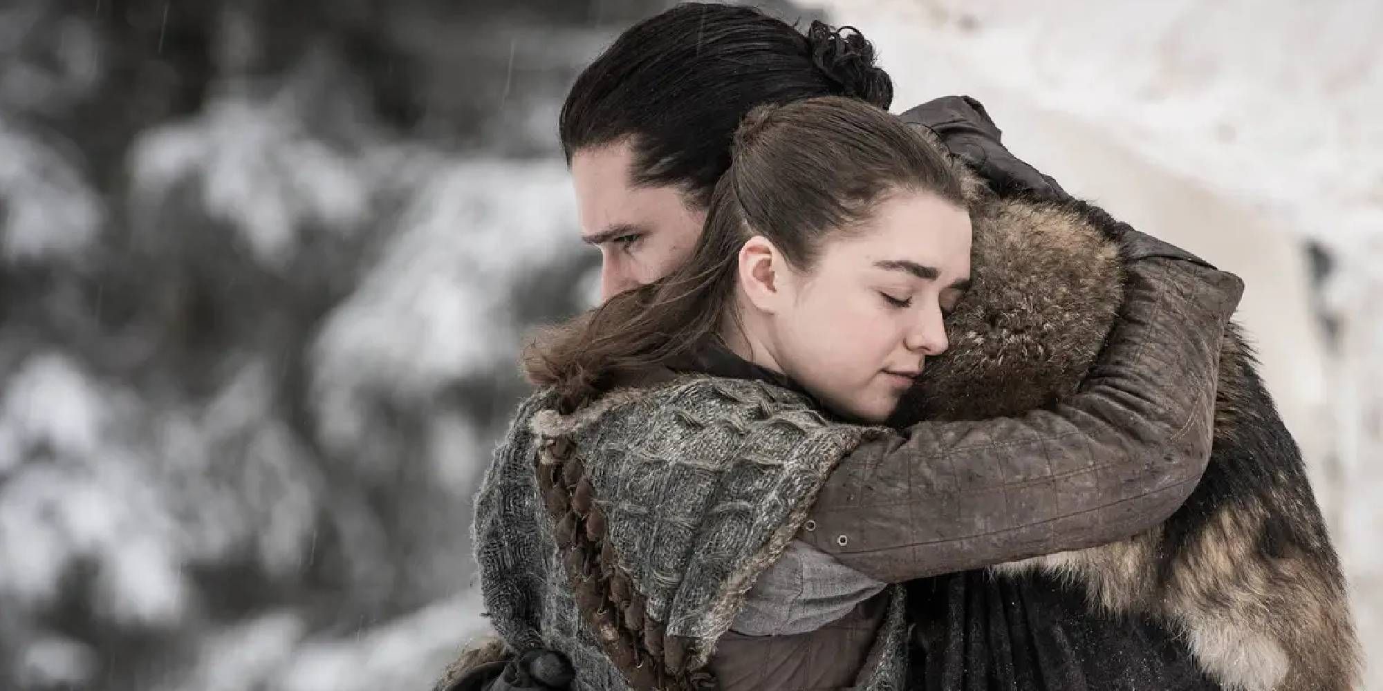 Kit Harrington and Maisie Williams as Jon Snow and Arya Stark hugging in Game of Thrones.