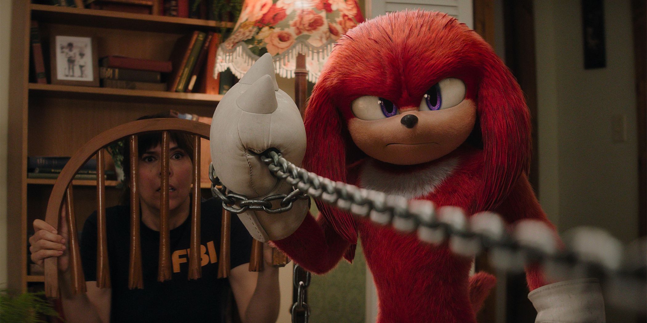 Wanda Whipple hiding behind a broken chair while Knuckles fights with a silver chain