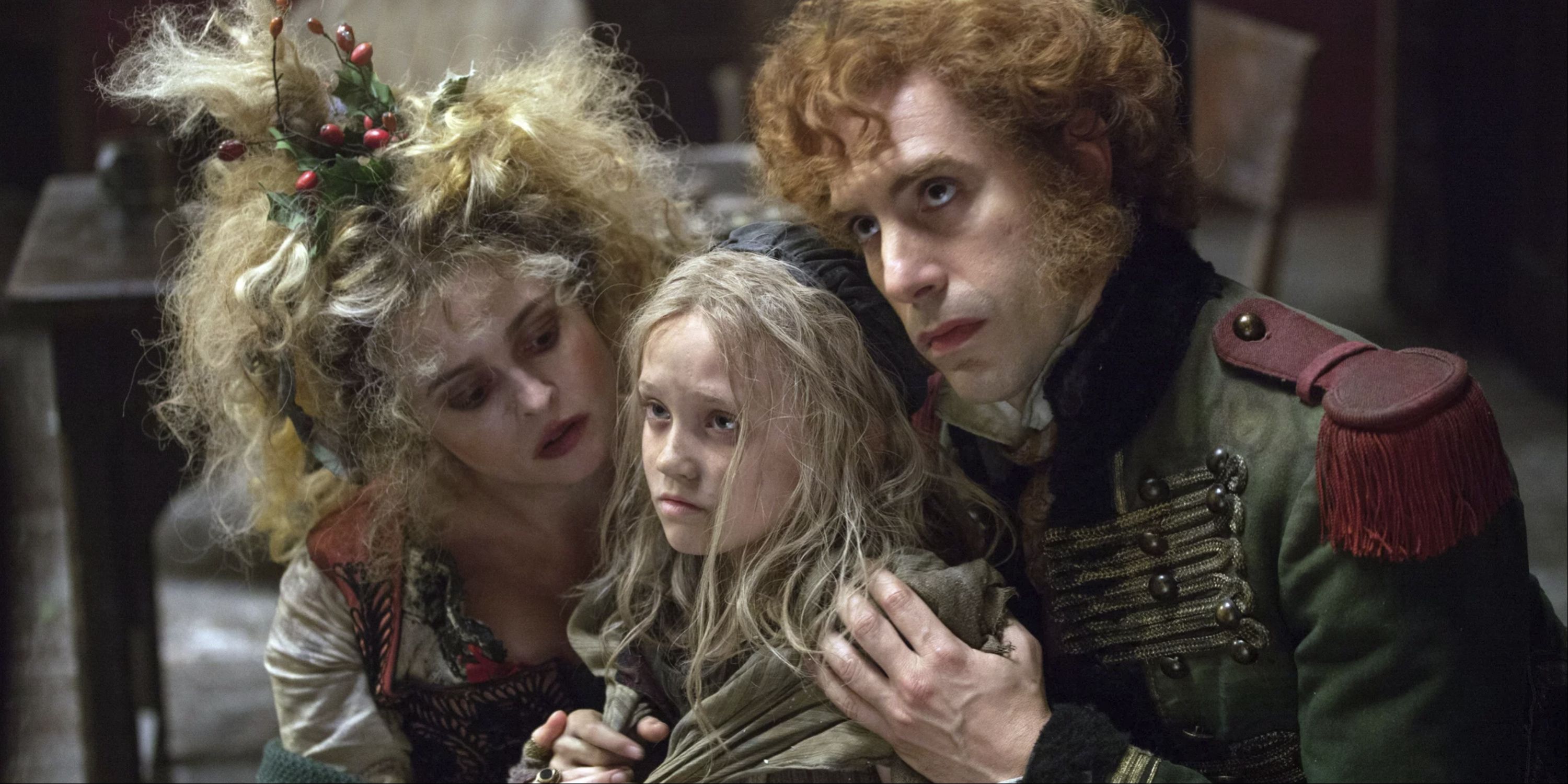 The Thenardiers, played by Helena Bonham Carter and Sacha Baron Cohen, put their hands on a scared Cosette in Les Miserables.