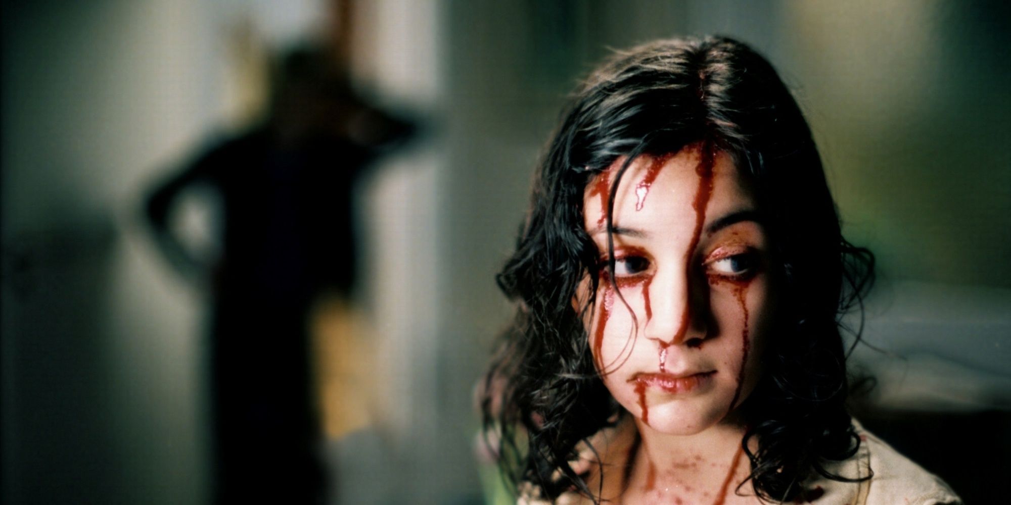 Lina Leandersson as Eli covered in blood in front of a shadowy figure in Let the Right One In