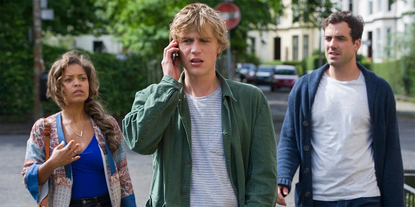 Johnny Flynn on the phone while Daniel Ings and Antonia Thomas walk behind him in Lovesick