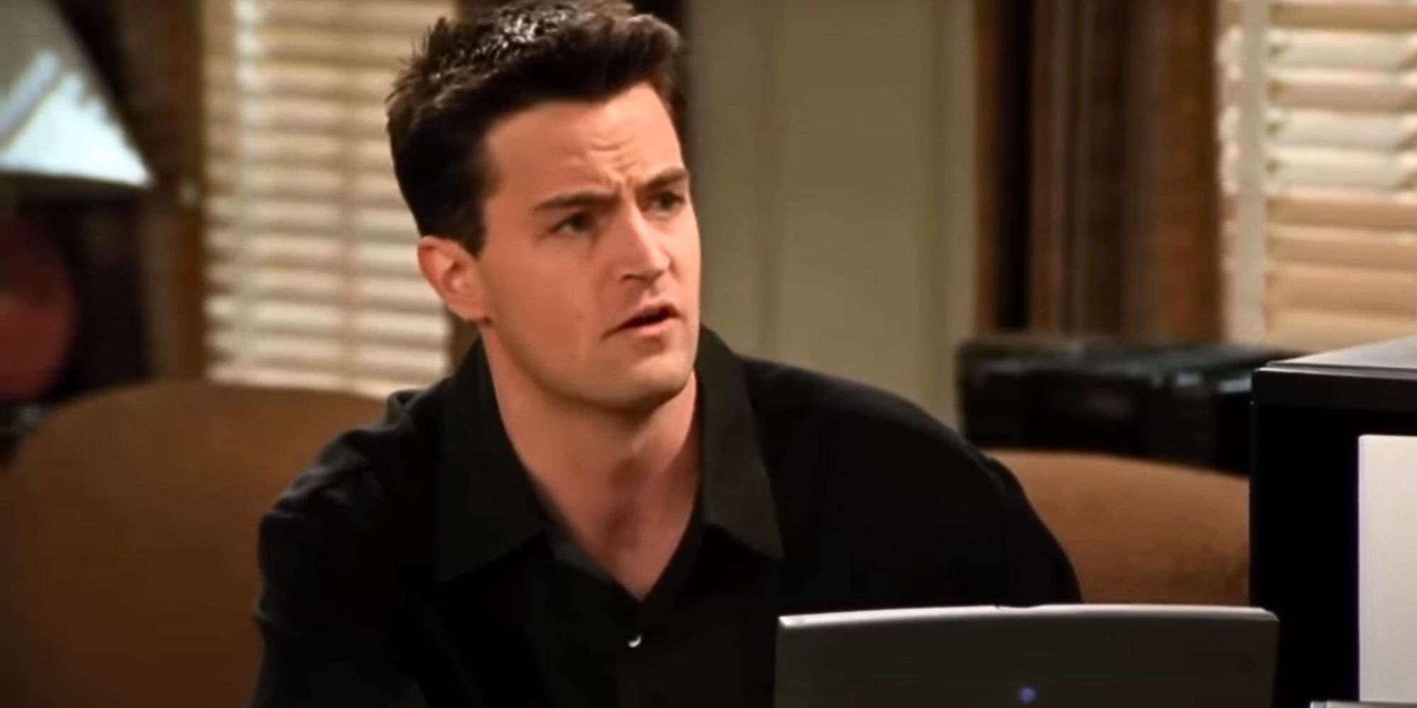 Matthew Perry as Chandler Bing sitting in front of a computer in Friends
