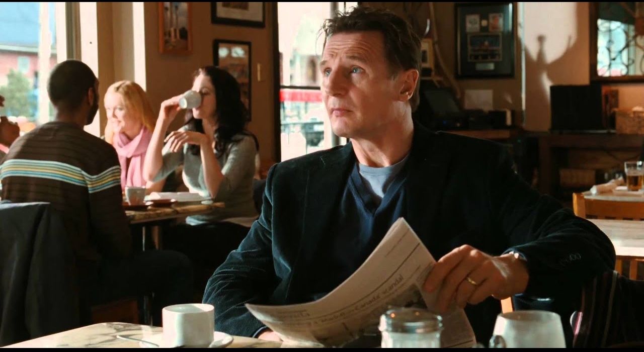 Liam Neeson reading the paper in a coffee shop in Chloe