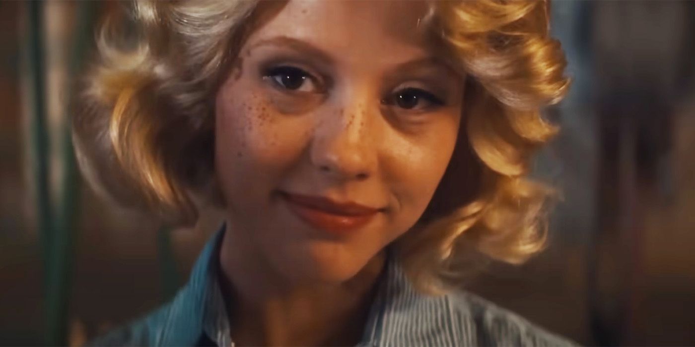 Mia Goth in a blonde wig smiling into the camera in Maxxxine