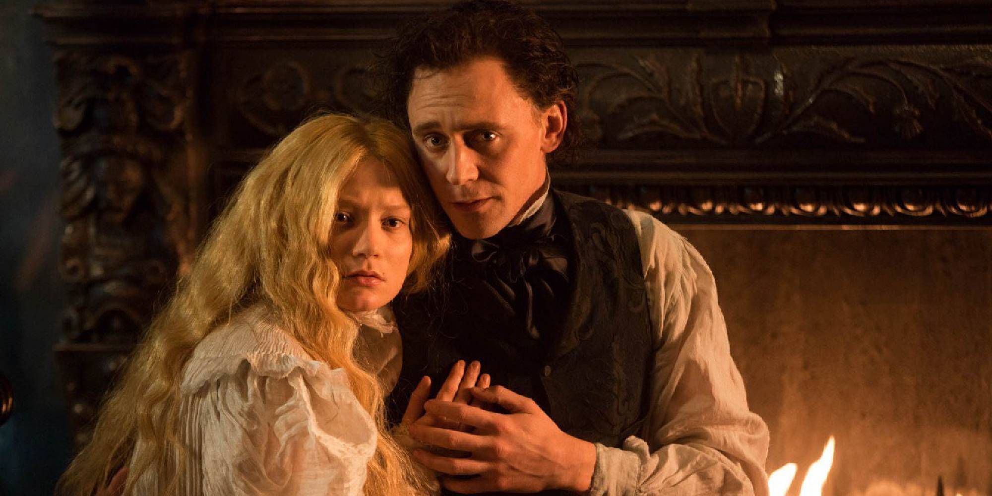 Mia Wasikowska as Edith looks worried while holding onto Tom Hiddleston as Thomas in Crimson Peak.