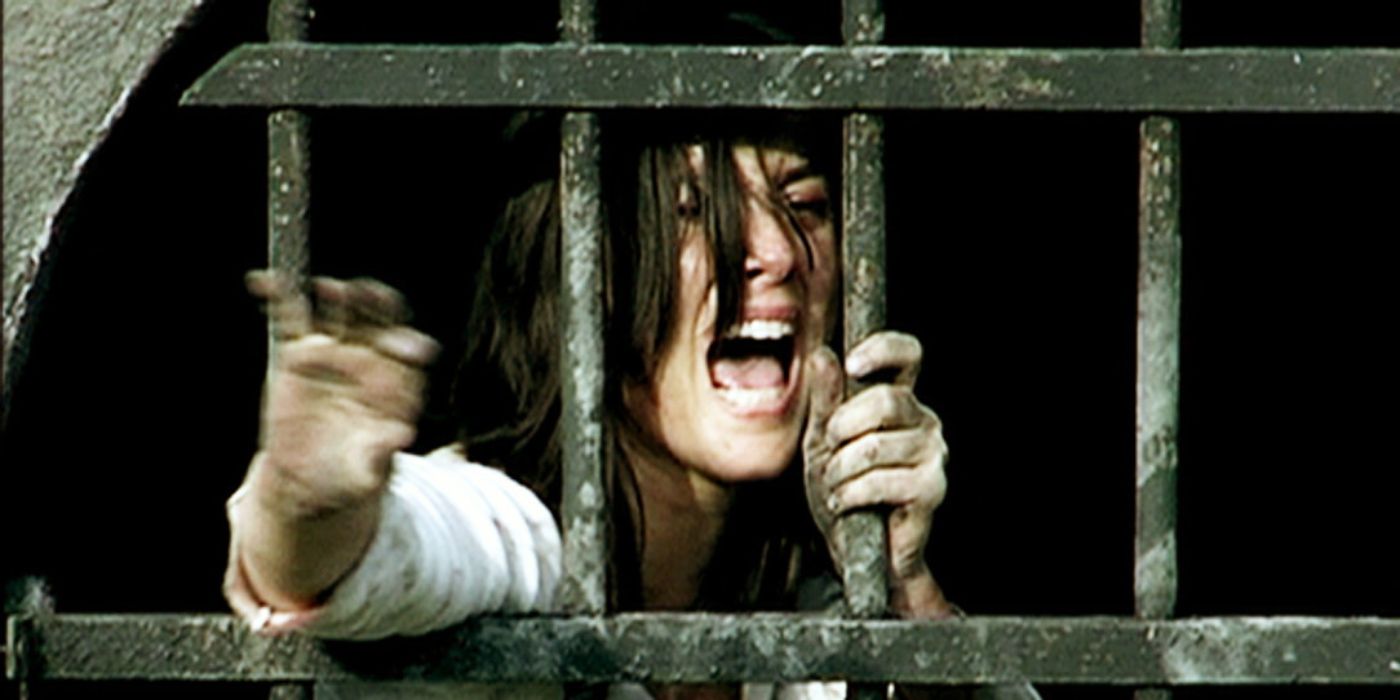 Olivia Bonamy in a scene in 'Them', reaching out to something through bars and screaming